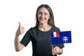 Happy young white woman holding flag of French Southern and Antarctic Territories and shows the class by hand isolated on a white