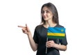 Happy young white woman holding flag Rwanda and points to the left isolated on a white background