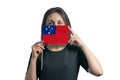 Happy young white woman holding flag Samoa flag and covers her face with it isolated on a white background