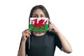 Happy young white woman holding flag Wales flag and covers her face with it isolated on a white background