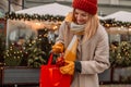 Stylish young beautiful happy woman walk with shopping bags and gift boxes on city street. Cheerful attractive girl Royalty Free Stock Photo