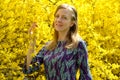 The happy young woman against the background of the blossoming .forsythia. Portrait