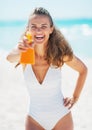 Happy young woman aiming bottle of sun block creme in camera Royalty Free Stock Photo