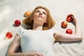 Happy young woman with apples lying on plaid
