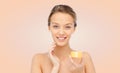 Happy young woman applying cream to her face Royalty Free Stock Photo