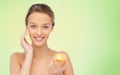 Happy young woman applying cream to her face Royalty Free Stock Photo