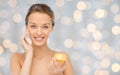 Happy young woman applying cream to her face Royalty Free Stock Photo