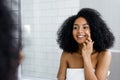 Happy young woman applying face cream Royalty Free Stock Photo