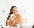 Happy young woman applying hair mask in bathroom Royalty Free Stock Photo