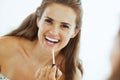 Happy young woman applying lip gloss in bathroom Royalty Free Stock Photo