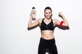 Happy young woman athlete with bottle of water showing biceps Royalty Free Stock Photo