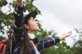 Happy young woman with backpack and hat, Traveler standing with raised arms and enjoying a beautiful nature Royalty Free Stock Photo