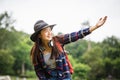 Happy young woman with backpack and hat, traveler standing with raised arms and enjoying a beautiful nature Royalty Free Stock Photo