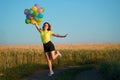 Happy woman with balloons at sunset in summer Royalty Free Stock Photo