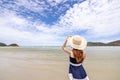 Happy young woman barefoot ware hat and walking on summer along wave of sea water and sand on the beach Royalty Free Stock Photo