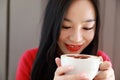 Happy young woman is under a blanket and cup of coffee on winter morning at home Royalty Free Stock Photo