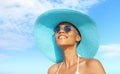 Happy young woman at the beach side, wearing a turquoise sun hat, blue sunglasses and bikini, portrait of African latin American Royalty Free Stock Photo