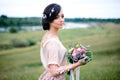 Happy young woman with a beautiful bouquet enjoys a spring day. Creative hairstyle with butterflies Royalty Free Stock Photo