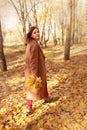 Happy young woman in a beige coast walks outdoors in autumn park, concept autumn. Royalty Free Stock Photo