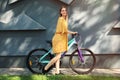 Happy young woman with bicycle near building Royalty Free Stock Photo