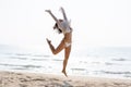 Happy young woman in bikini jumping on the beach Royalty Free Stock Photo