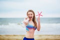 Happy young woman in bikini with snorkelling equipment and pink starfish Royalty Free Stock Photo