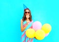 Happy young woman in a birthday cap with an air colorful balloons Royalty Free Stock Photo