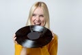 Happy Young Woman biting a Vinyl Record Royalty Free Stock Photo