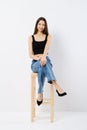 Happy young woman in black tank top and wide jeans on chair Royalty Free Stock Photo