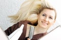 Happy young woman blow drying hair in bathroom Royalty Free Stock Photo