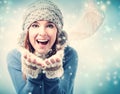 Happy young woman blowing snow