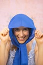happy young woman with blue headscarf standing in front rusty metal background