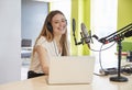 Happy young woman broadcasting in a studio, close up