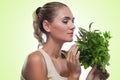 Happy young woman with a bundle of fresh mint. Concept vegetarian dieting - healthy food