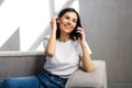 Happy young woman caller talking on the phone at home, cheerful teen girl enjoys pleasant mobile conversation in living room Royalty Free Stock Photo