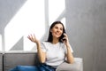 Happy young woman caller talking on the phone at home, cheerful teen girl enjoys pleasant mobile conversation in living room Royalty Free Stock Photo