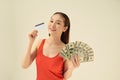 Happy young woman with cash money and credit card on gray background Royalty Free Stock Photo