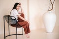 Happy young woman in casual clothes sitting in metal chair Royalty Free Stock Photo
