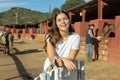 Happy young woman in casual clothes standing near fence and smiling at camera during visit of horse ranch Royalty Free Stock Photo