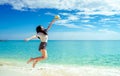 Happy young woman in casual style fashion and straw hat jumping at sand beach. Relaxing and enjoy holiday at tropical paradise Royalty Free Stock Photo