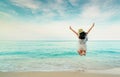 Happy young woman in casual style fashion and straw hat jumping at sand beach. Relaxing, fun, and enjoy holiday at tropical