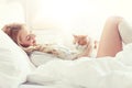 Happy young woman with cat in bed at home Royalty Free Stock Photo