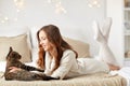 Happy young woman with cat lying in bed at home Royalty Free Stock Photo