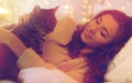 Happy young woman with cat lying in bed at home Royalty Free Stock Photo