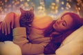 Happy young woman with cat lying in bed at home Royalty Free Stock Photo