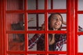 Happy young woman chatting on a public phone Royalty Free Stock Photo