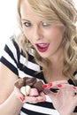 Happy Young Woman Choosing Which Chocolates to eat