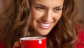 Happy young woman in christmas red dress having cup of hot bever Royalty Free Stock Photo