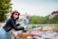 Happy young woman with a city map in Europe. Travel tourist woman with map in Prague outdoors during holidays in Europe. Royalty Free Stock Photo