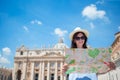 Happy young woman with city map in Vatican city and St. Peter's Basilica church, Rome, Italy. Travel tourist woman with Royalty Free Stock Photo